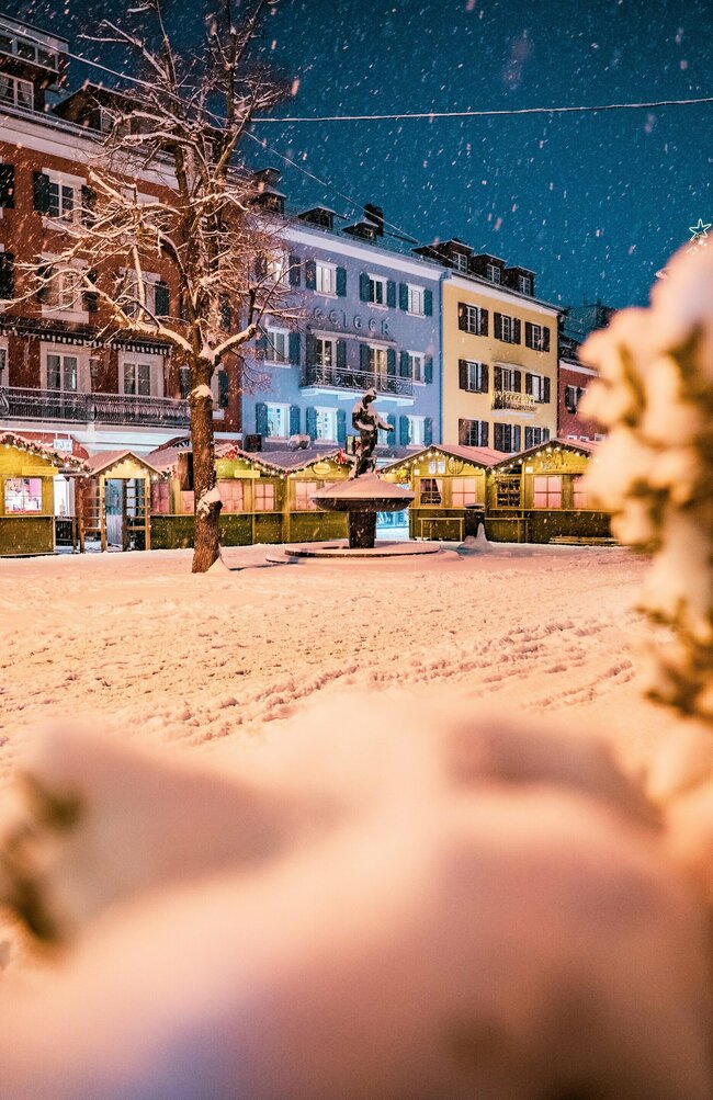 Der verschneite Lienzer Hauptplatz mit den Hütten des Adventmarkts.