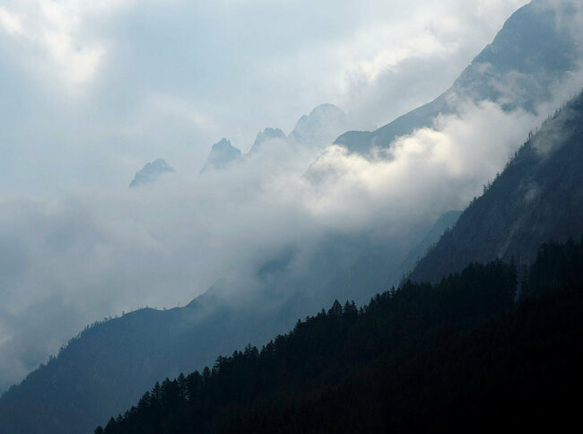 Tristach Mystische Bergsilhouette mit Nebeschwaden.