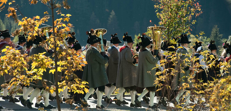 Fest im Herbst Zwischen zwei verfärbten Bäume sieht man Häuser eines Dorfes.