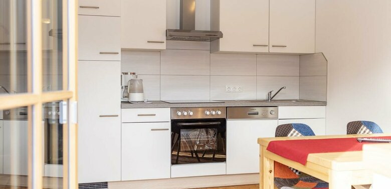 Küchenblock in einer Ferienwohnung mit Holzboden und einem Esstisch vom Balkon aus