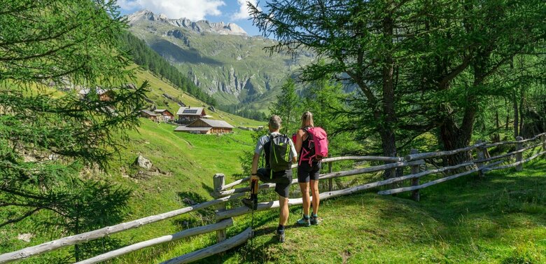 Blick auf die äußere Steiner Alm Weitwandern auf der Glocknerkrone in Osttirol, Etappe 1. Zwei Wanderer genießen den Blick auf die Äußere Steiner Alm.