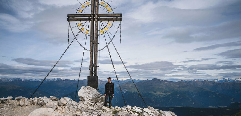 Große Kinigat Ein Wanderer am Gipfelkreuz des Berges Große Kinigat.