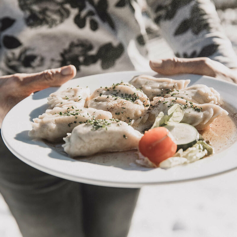 Osstiroler Schlipfkrapfen Osstiroler Schlipfkrapfen mit Schnittlauch und geschmolzener Butter und einem kleinen gemischten Salat.
