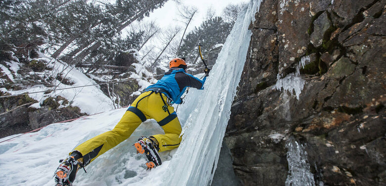 Eisfestival 2017 Eiskletterer klettert auf einem zugefrorenen Wasserfall senkrecht nach oben
