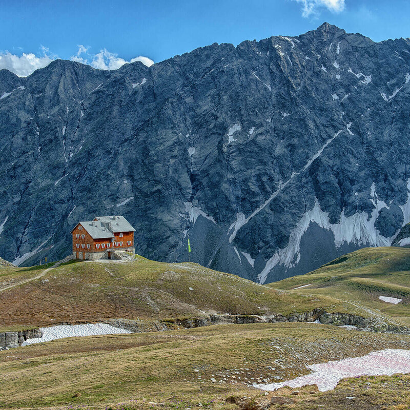 Neue Reichenbergerhütte Blick auf die Neue Reichenbergerhütte vor einem Felsmassiv mit letzten Schneeresten.