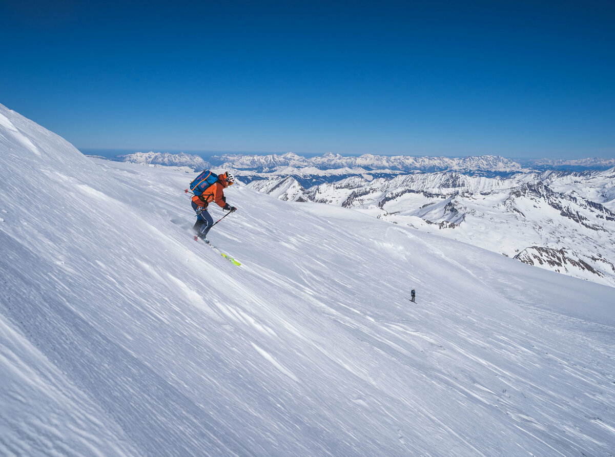 Abfahrt Richtung Venedigerscharte Ein Skifahrer bei der Abfahrt Richtung Venedigerscharte mit Bergkulisse und blauem Himmel.