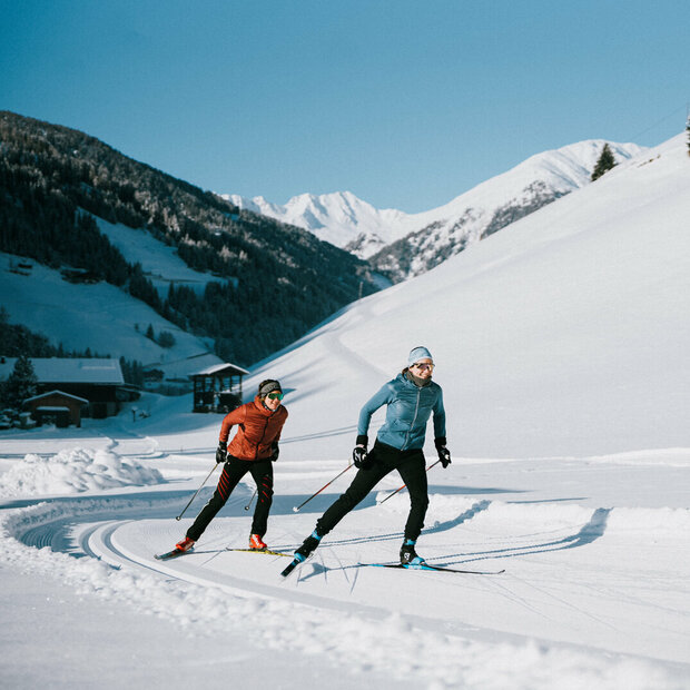 Ob Skating oder Klassisch: Auf Osttirols Loipen ist für jede:n etwas dabei. Zwei Langläufer:innen bei perfekten Loipen- und Wetterbedingungen in Innervillgraten.