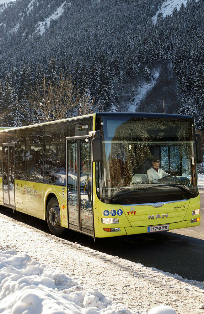 Postbus im Winter Bus inmitten einer Winterlandschaft.
