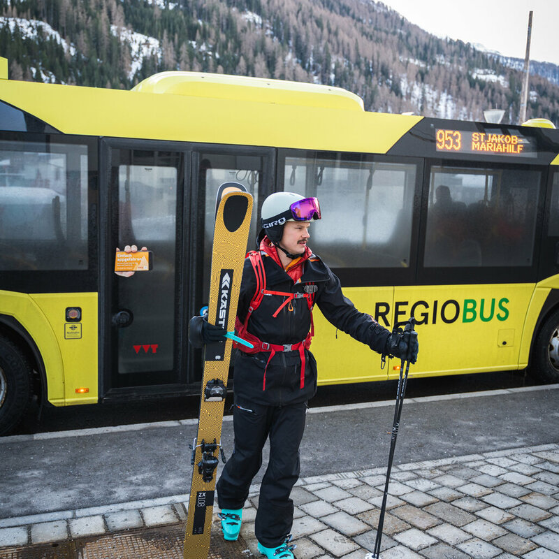 Skifahrerin steigt aus dem Skibus und ist bereit für ihr Skiabenteuer in St. Jakob im Defereggental