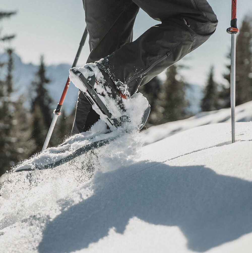 Schneeschuhwandern Die Beine eines Mannes beim Schneeschuhwandern durch den Tiefschnee.