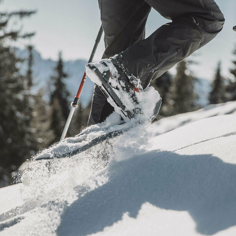 Schneeschuhwandern Die Beine eines Mannes beim Schneeschuhwandern durch den Tiefschnee.