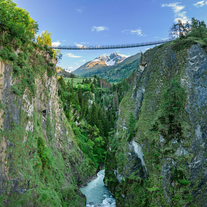 Die neue Hängebrücke führt in 80 Metern Höhe sicher über die Iselschlucht. Darunter verläuft der blaue Gletscherfluss Isel.