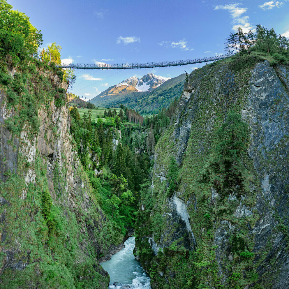 Die neue Hängebrücke führt in 80 Metern Höhe sicher über die Iselschlucht. Darunter verläuft der blaue Gletscherfluss Isel.