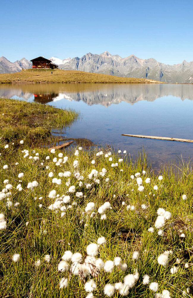 Zupalsee Hütte Der Zupalsee spiegel in seinem klaren Wasser die Zupalsee Hütte und die umliegende Bergwelt wider.