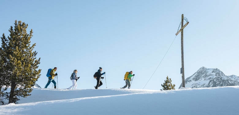 Eine Gruppe beim Schneeschuhwandern bei sonnigem Wetter im Nationalpark Hohe Tauern in Osttirol