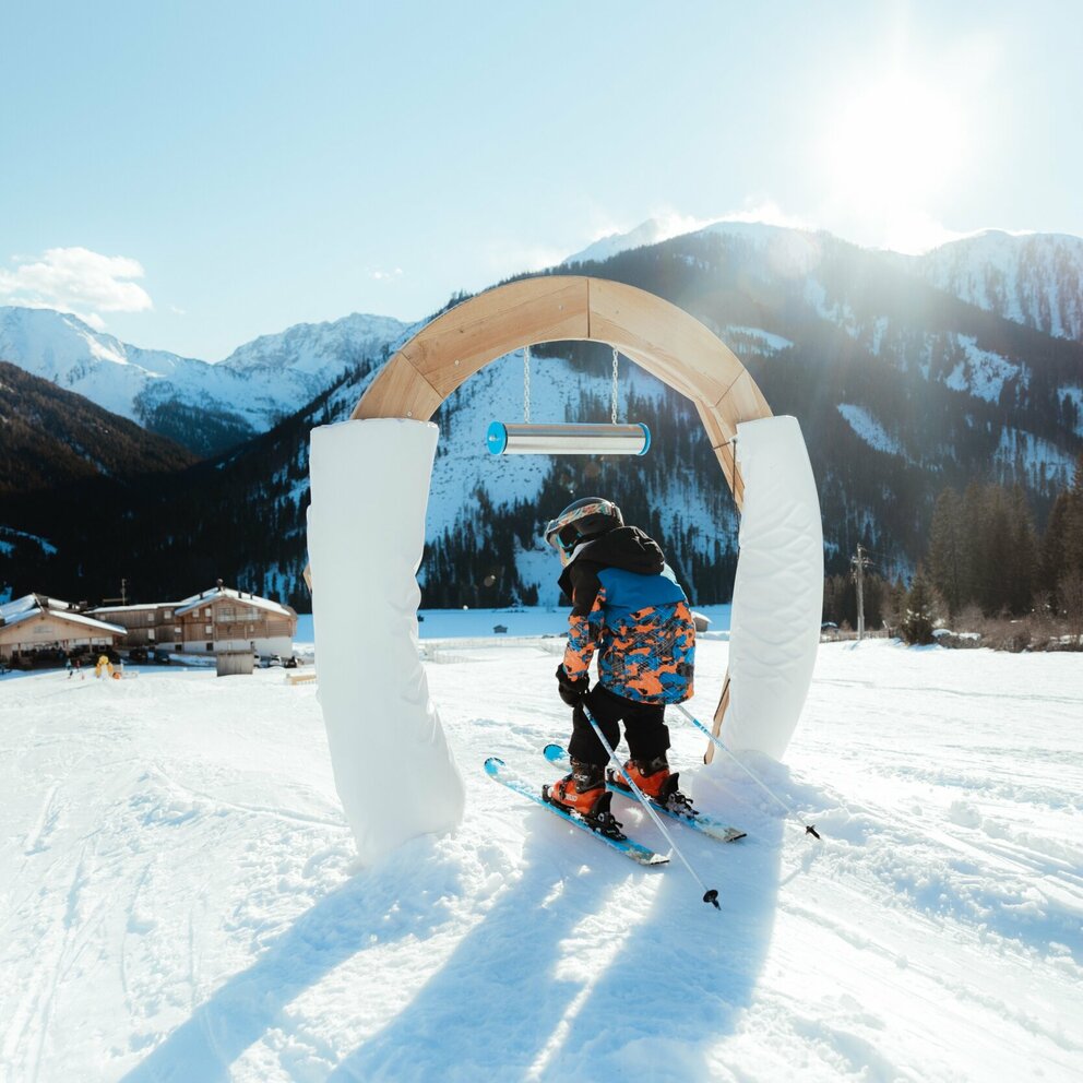 Skifahren durch Bogen Obertilliach Kleiner Skifahrer führt durch Bogen im Kinderland in Obertilliach