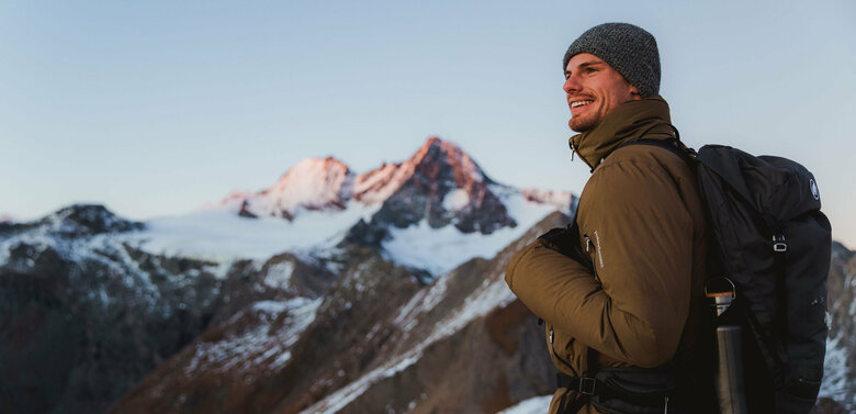 Figerhorn Wanderer nach Sonnenuntergang am Figerhorn mit dem schneebedeckten Großglockner im Hintergrund.