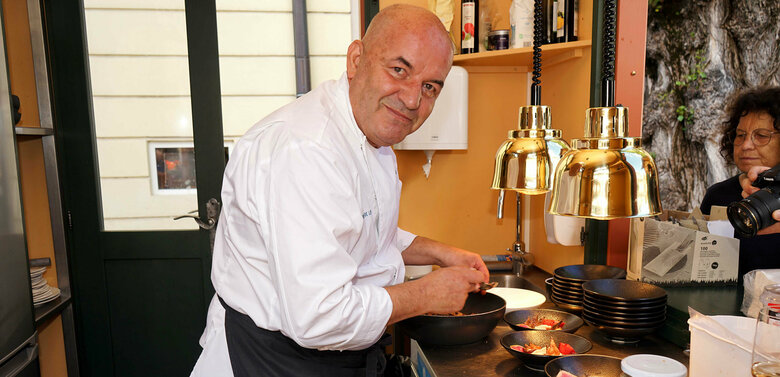 Koch Ernst Moser beim Anrichten seiner Speisen in seinem Stand am Lienzer Hauptplatz beim Osttirol Deluxe.