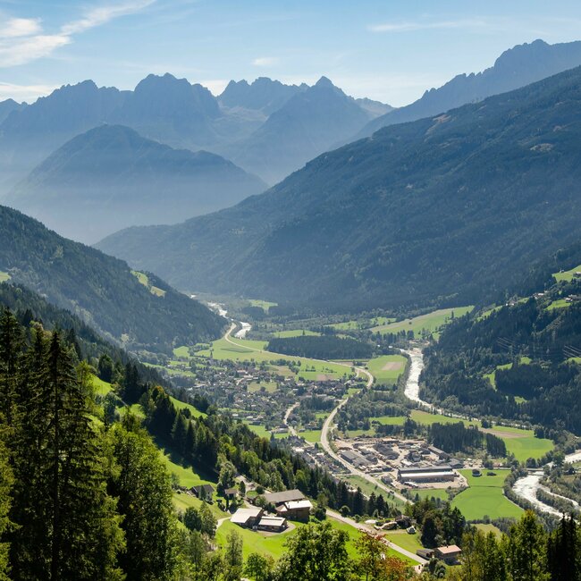 Ortsansicht Ainet im Sommer Ortsansicht Ainet im Sommer von einem höher gelegenen Aussichtspunkt mit Bergpanorama bei blauem Himmel im Hintergrund.