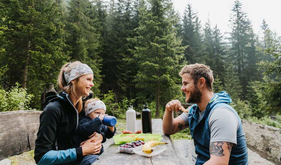 Jause Familienwanderung Kristeinertal Eine junge Familie sitzt auf einer Bank und macht eine Jause während der Familienwanderung im Kristeinertal.