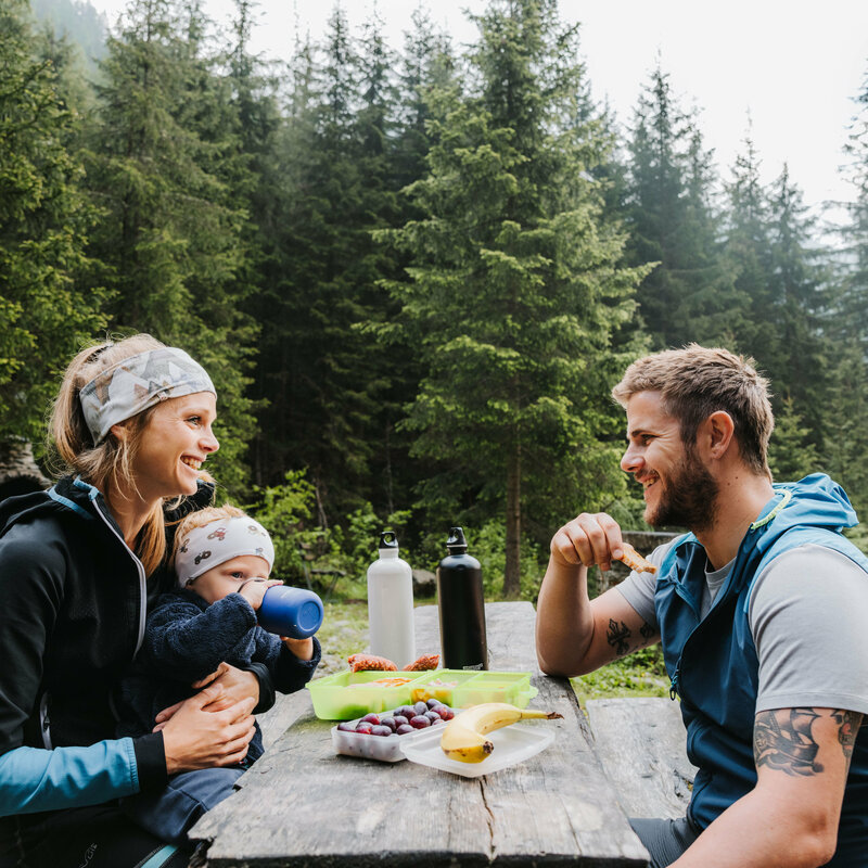Jause Familienwanderung Kristeinertal Eine junge Familie sitzt auf einer Bank und macht eine Jause während der Familienwanderung im Kristeinertal.