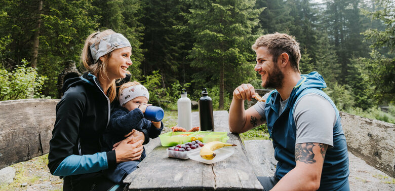Jause Familienwanderung Kristeinertal Eine junge Familie sitzt auf einer Bank und macht eine Jause während der Familienwanderung im Kristeinertal.