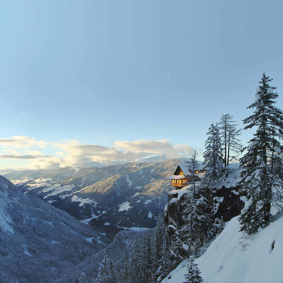 Dolomitenhütte Panorma Panoramablick auf die beleuchtete Dolomitenhütte im Winter. Die Landschaft ist tief verschneit.