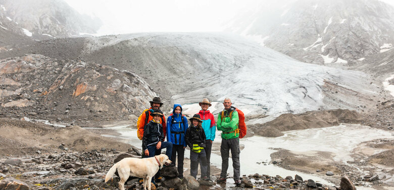 Am Gletscher Familie mit Hund bei einer Rangertour im Nationalpark Hohe Tauern bei schlechtem Wetter.