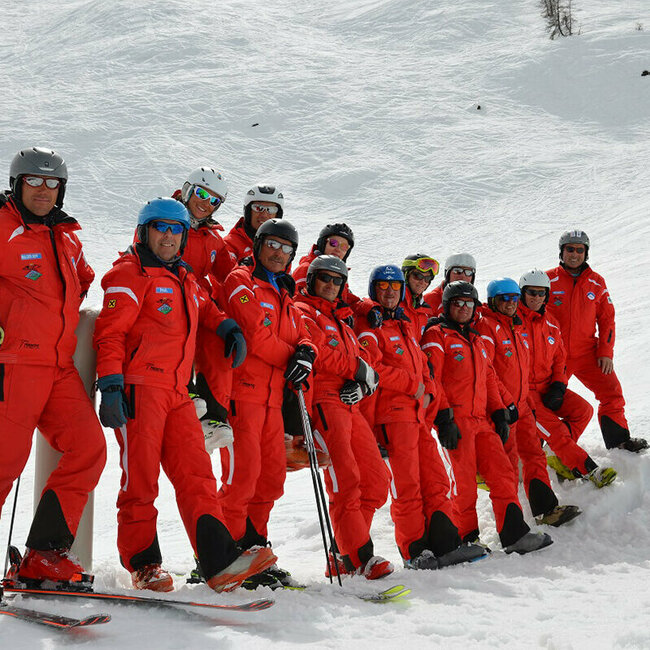 Wintersportschule Hochpustertal Team der Skischule White Element im Skizentrum Hochpustertal mit ihren auffälligen roten Skianzügen auf der Piste.