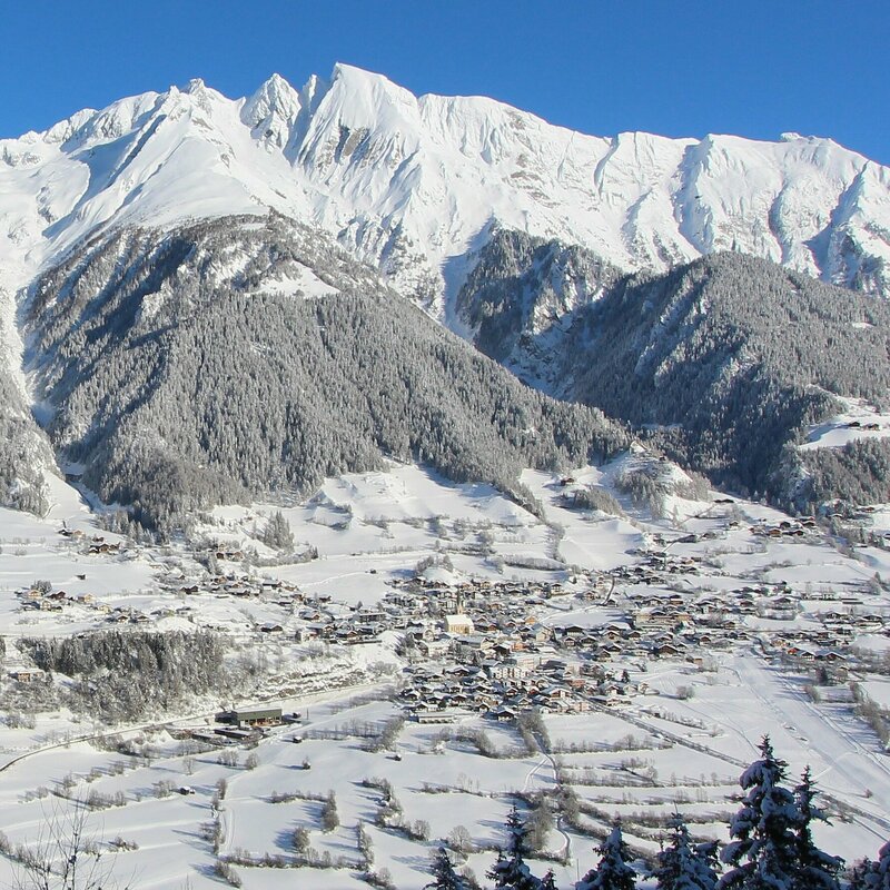 Winterbild von Virgen Die Gemeinde Virgen liegt tief verschneit vor imposanten Berggipfeln.
