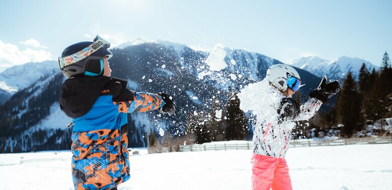 Schneeballschlacht Kinderland Obertilliach Zwei Kinder machen eine lustige Schneeballschlacht im Kinderland in Obertilliach bei strahlend schönem Wetter.