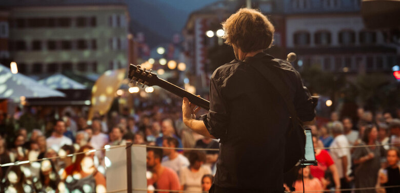 Ein Gitarrist auf der großen Bühne am Hauptplatz beim Sommerfest in Lienz 2024 in Osttirol.