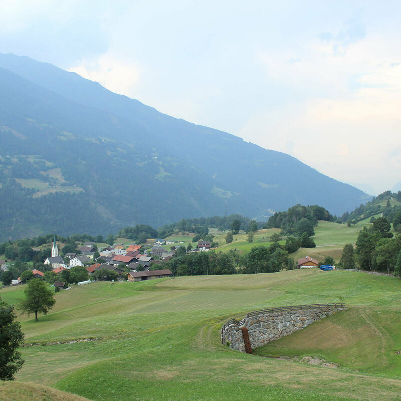 Schlaiten Blick auf eine große Wiese mit der Gemeinde Schlaiten im Hintergrund.