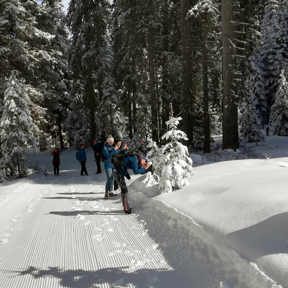 winterwandern-kartitsch Personen beim Fotografieren des verschneiten Waldes während des Winterwanderns