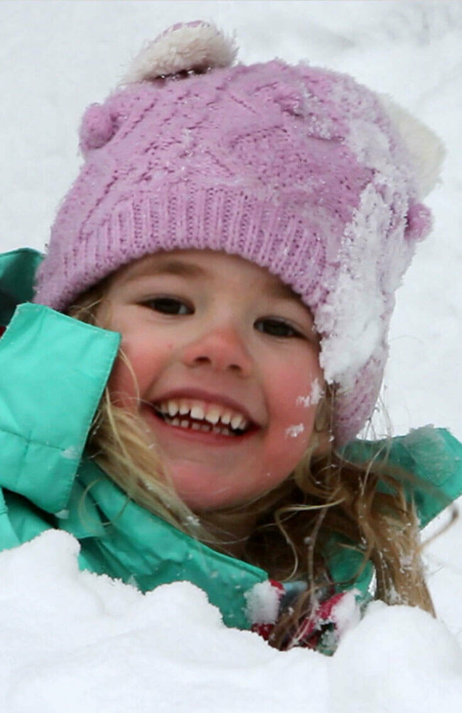 Spielplatz Schnee Ein Kind spielt fröhlich im frischen Schnee