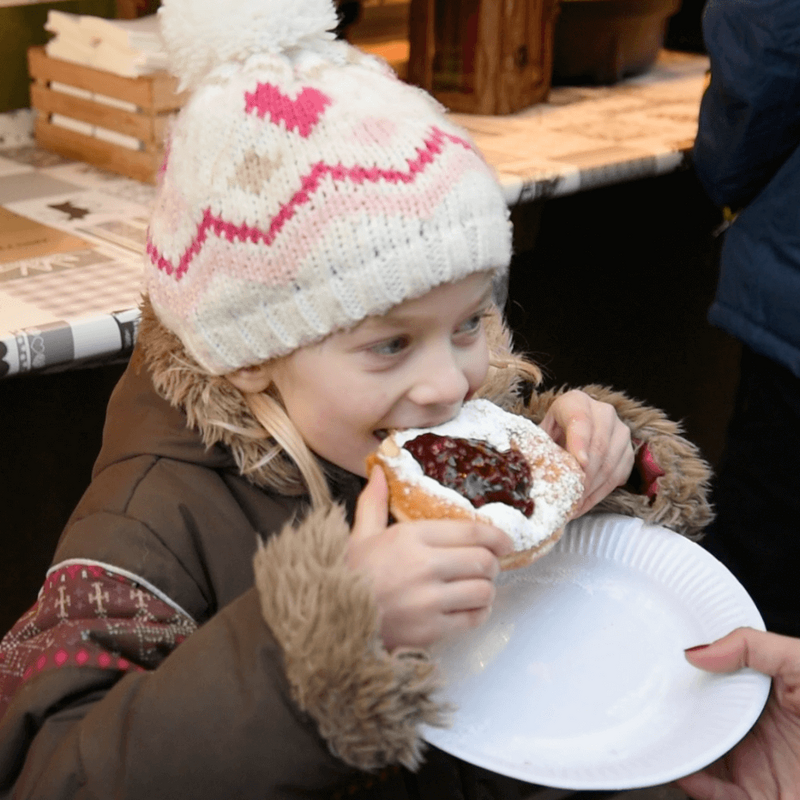 Lienzer Christkindlmarkt Kind beim Genuss einer Süßigkeit am Lienzer Christkindlmarkt