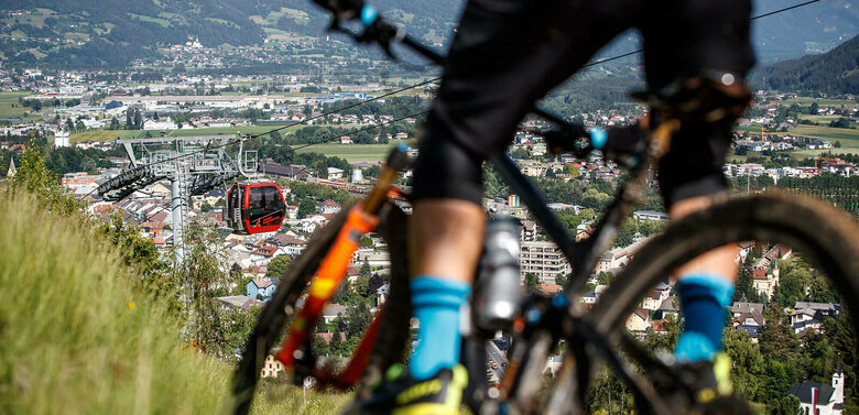 Alban Lakata Trail Bikepark Lienz Nahaufnahme eines Radlfahrers auf dem Alban Lakata Trail im Bikepark Lienz, mit Blick auf die Lienzer Bergbahn und die Stadt.