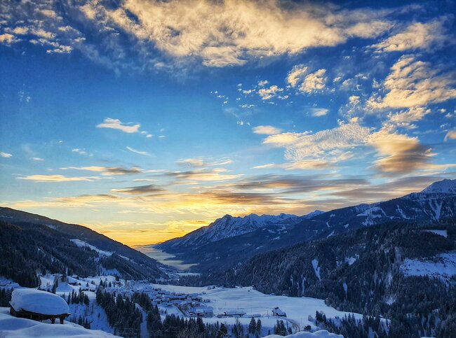 Romantische Atmosphäre beim Blick ins verschneite Lesachtal bei Sonnenaufgangsstimmung.