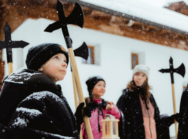 Nachtwächter mit Kindern Mehrere Kinder im Schneefall bei einer Nachtwächter Wanderung in Obertilliach.