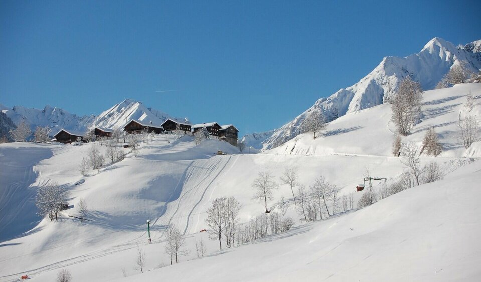 Skigebiet Bichllift Das schneebedeckte Skigebiet Bichllift. Blick auf einen Skilift und mehrere Gebäude auf einem Hügel.