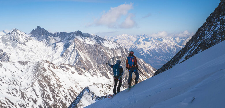 Hoch Tirol plus Ausblick Regentörl Zwei Skitourengeher:innen genießen den Ausblick aufs Regentörl und blicken in die verschneite Berglandschaft.