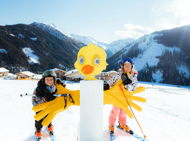 Kinderland Golzentipp Obertilliach Zwei Kinder stehen an einer farbenfrohen Entenfigur im Kinderland in Obertilliach