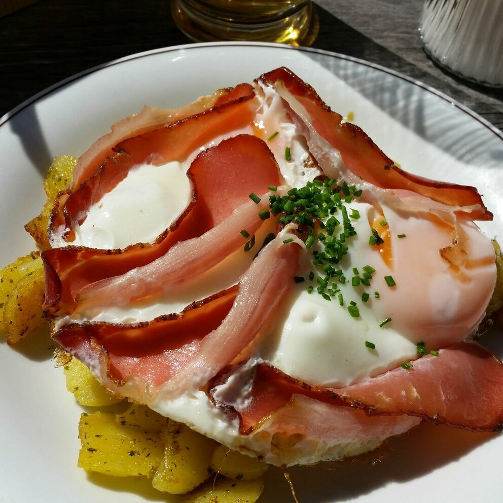 Regionale Küche Auf dem Bild zu sehen ist ein schön angerichteter Teller mit Bratkartoffeln, Spiegelei und Speck
