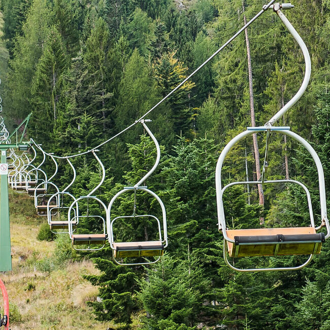 Lienzer Bergbahn Hochstein Sessellift Zwei Liftfahrer drehen sich während der Fahrt mit dem Sessellift der Lienzer Bergbahn Hochstein zur Kamera um.