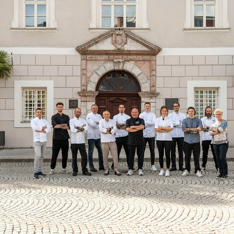 Die Köchinnen und Köche von Osttirol de luxe 2025 in klassischer Kochbekleidung vor der Lienzer Liebburg.