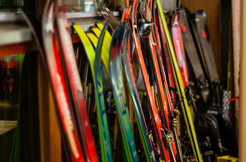 Skiverleih Verschiedene Ski stehen nebeneinander angelehnt an einen Ständer.