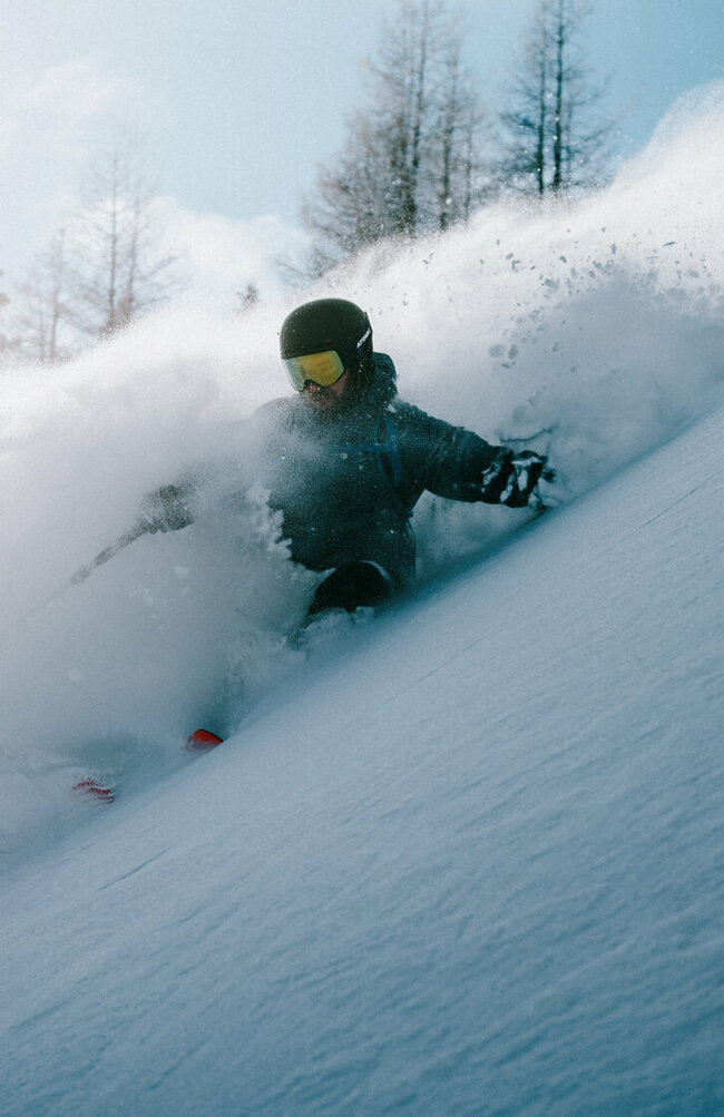 Abfahrten vom Allerfeinsten erwarten dich auf Osttirols Skitourenrouten. Ein Skitourenfahrer bei der Abfahrt von der Roten Wand im Defereggental. Er fährt durch Tiefschnee und Trägt Helm, Skibrille und Stöcke.