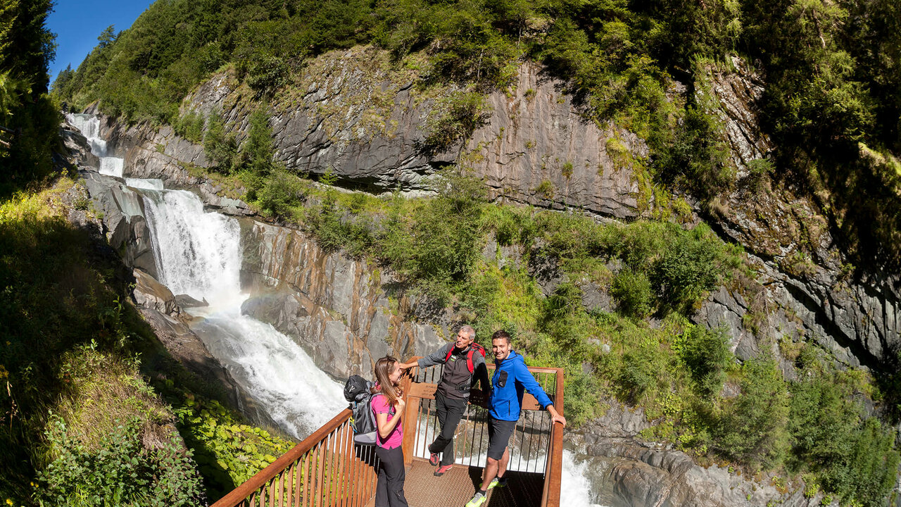 Aussichtsplattform Drei Gäste auf einer Aussichtsplattform vor den Umballfällen.
