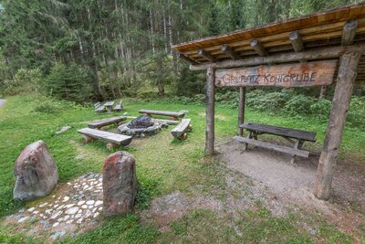 Grillplatz Kohlgrube in Hopfgarten Der Grillplatz Kohlgrube in Hopfgarten i. D.. Zu sehen ist ein mit Holz überdachter Grill der neben einer gemütlichen Sitzgelegenheit steht. Diese besteht aus vier Bänken die um einen Lagerfeuerplatz herum gestellt wurden.