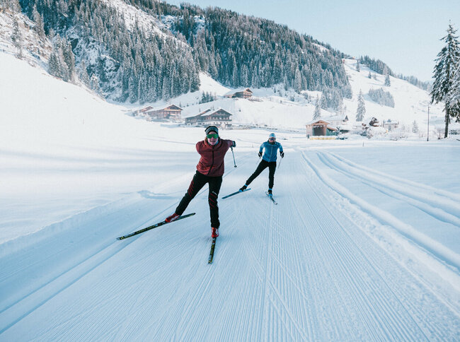 Zwei Langläufer:innen in Action auf der gespurten Loipe in Innervillgraten